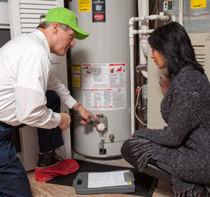 plumber showing woman what's wrong with water heater