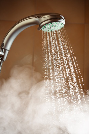 steaming shower head with water running