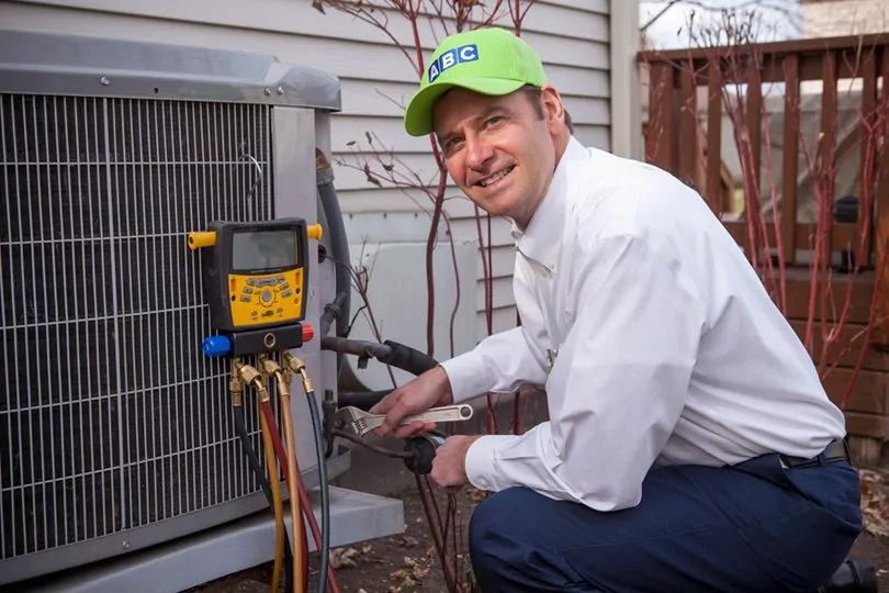 ABC technician operating on outdoor HVAC unit