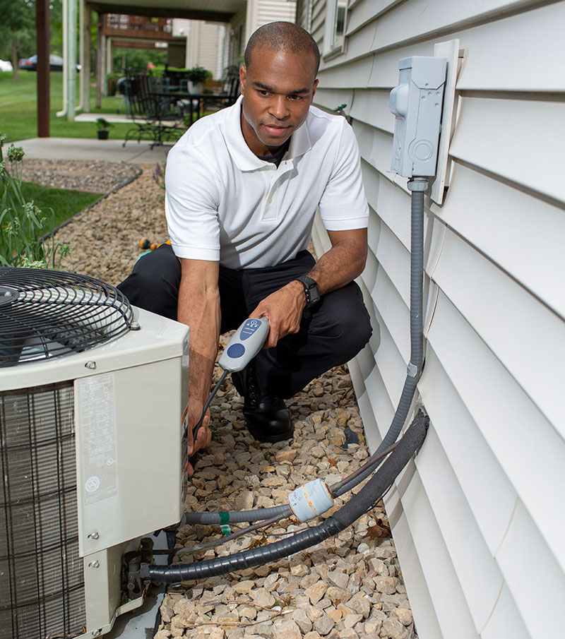 HVAC technician working on an outside AC unit