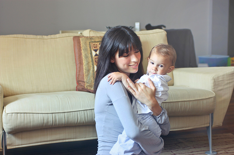 woman sitting on floor holding toddler