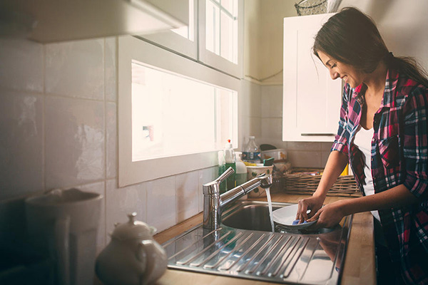 woman washing dishes in sink