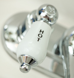 A closeup of a hot water faucet turned on