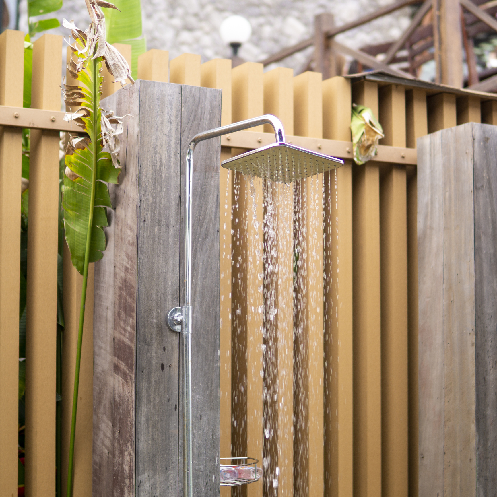 Water falling from the rain shower head of a swimming pool open area showers.