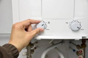 homeowner adjusting temperature settings on tankless water heater