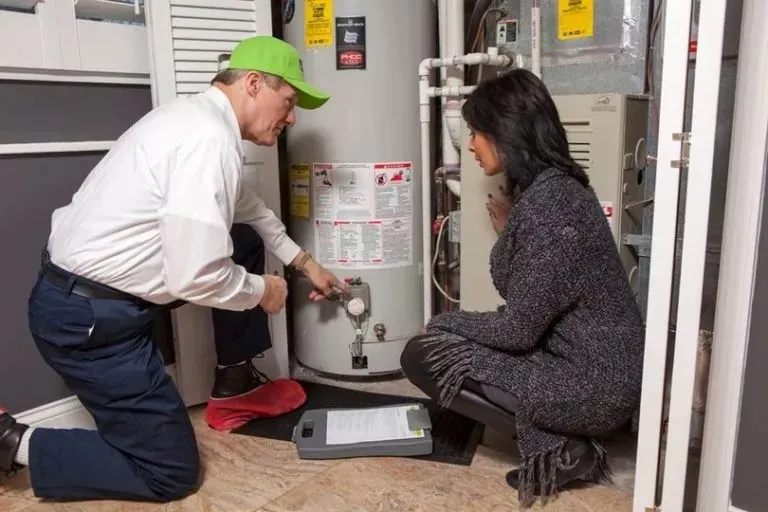 Plumber helping residential water heater client