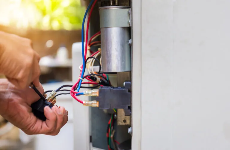 Close up of an HVAC technician fixing air conditioning system by changing magnetic contactor