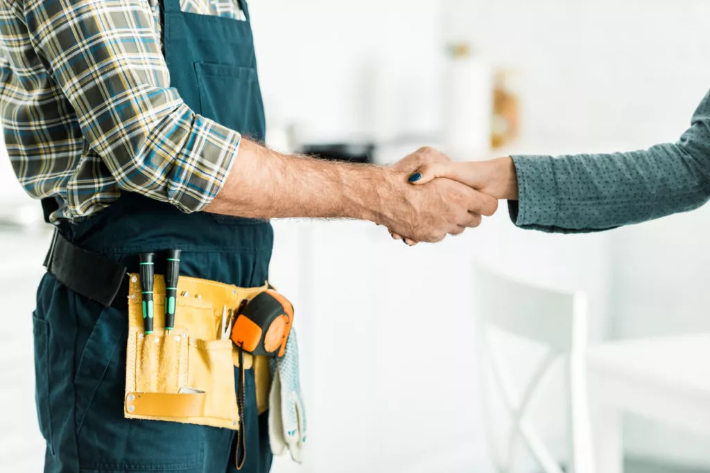 cropped image of Cape Haze plumber and client shaking hands in kitchen