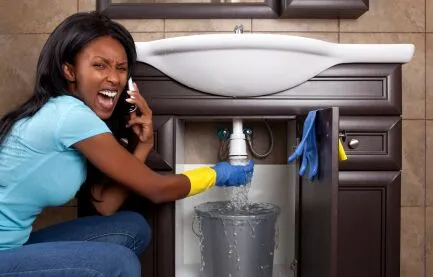 Woman on the phone while sink is leaking behind her